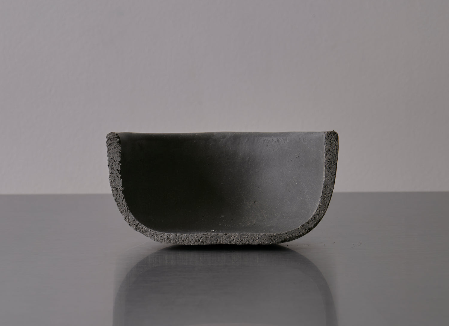 Cross-sectional view of a clay bowl that has been cut in half, highlighting how thick the walls are