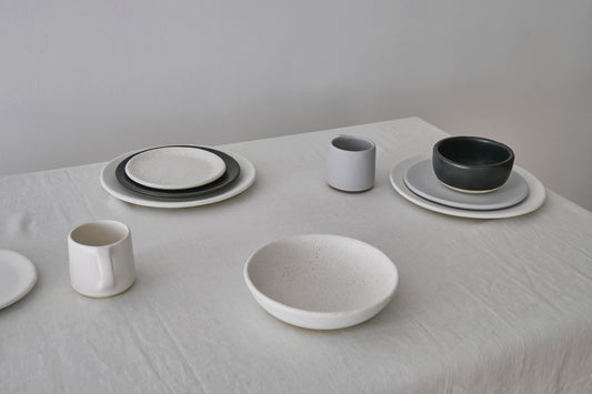 Modern table set with white, gray, and black dishes